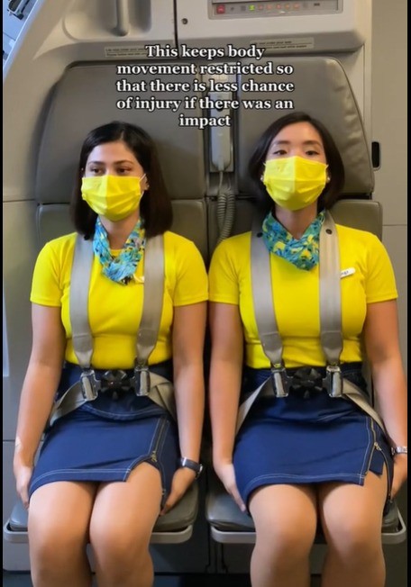 In einem TikTok-Video wird darüber aufgeklärt, warum Flugbegleiter*innen auf ihren Händen sitzen.