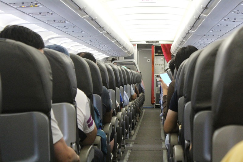 Passagiere zusammen mit einer Stewardess.