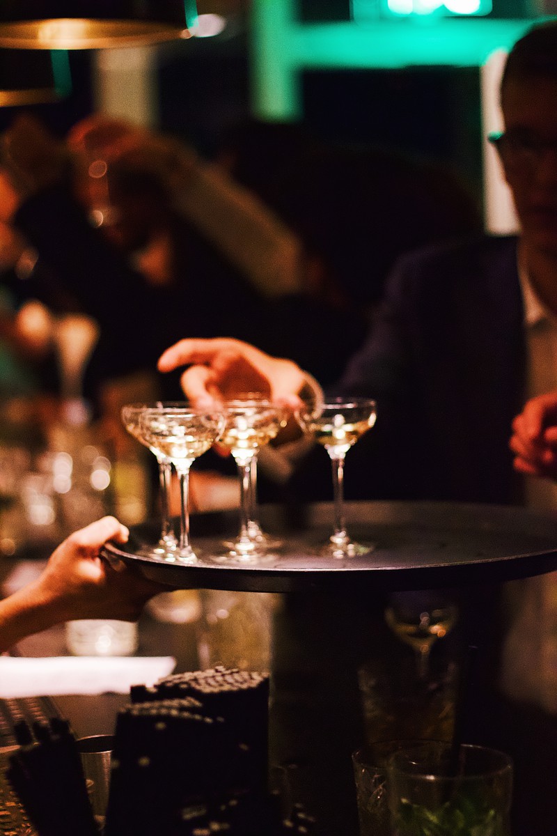 Ein Kellner bringt Cocktails, die die Geschichte des Onkels und das Familiendinner noch aufheitern werden