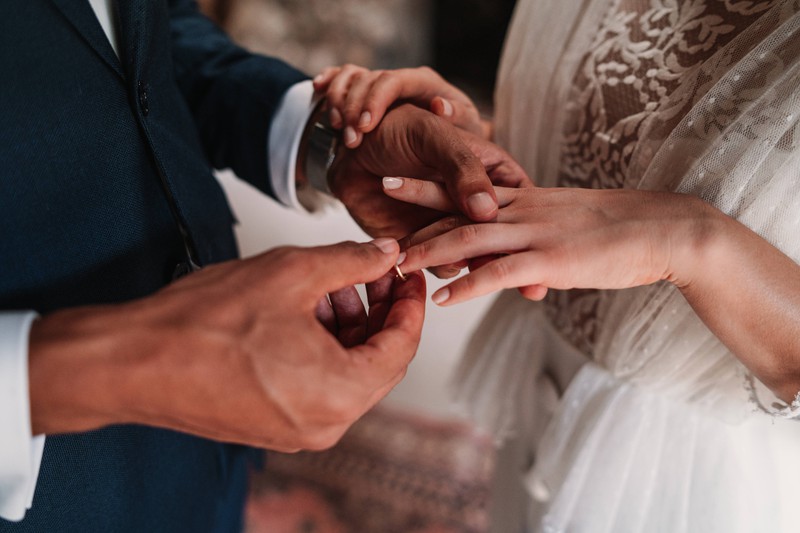 Ein Mann steckt seiner Frau einen Ring an den Finger