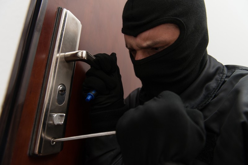 Ein Einbrecher öffnet eine Tür