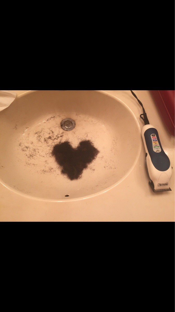 Ein Mann hat Haare im Waschbecken zu einem Herzen geformt