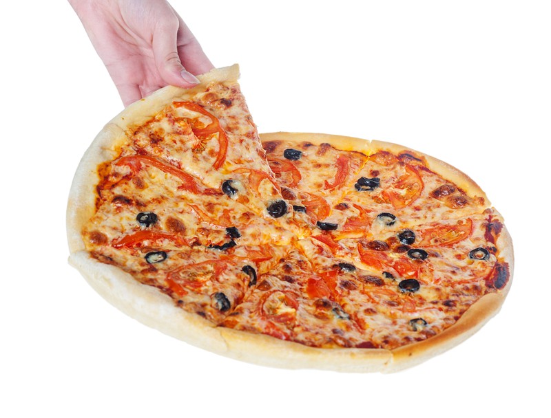 Eine Person greift ein Stück Pizza