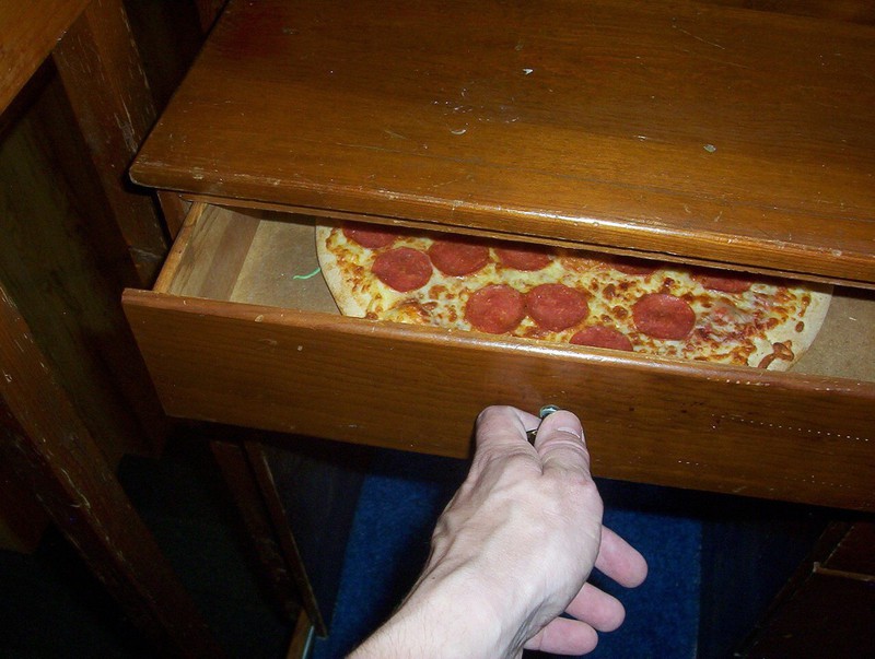 Zu sehen ist eine Pizza, die in einer Schublade liegt.