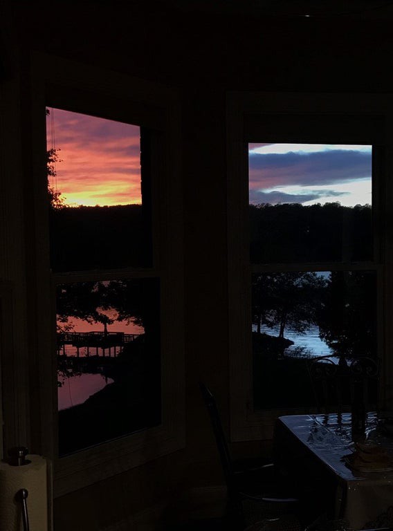 Man sieht eine optische Täuschung in Form eines Sonnenunterganges am Fenster.