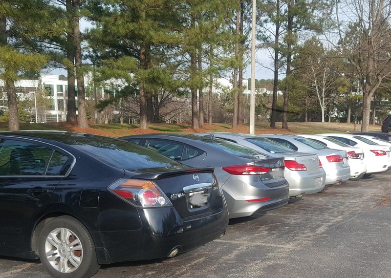 Man sieht eine optische Täuschung in Form von Autos, die zufällig der Farbe nach sortiert geparkt haben.