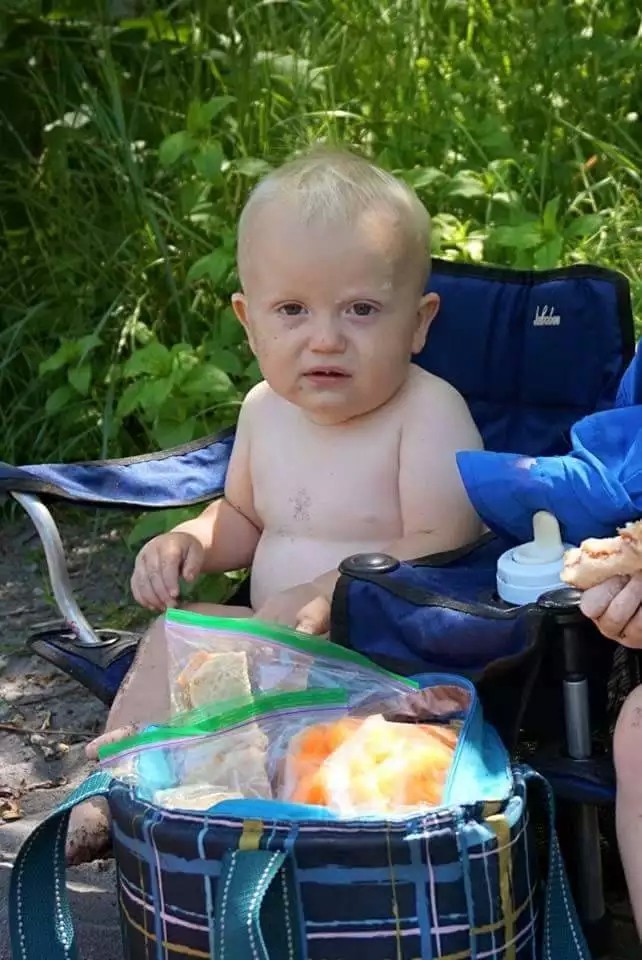 Ein Baby sitzt und sieht aus wie ein Opa.