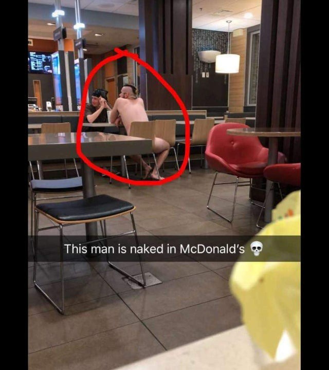 Mann sitzt ohne Kleider in einem Restaurant