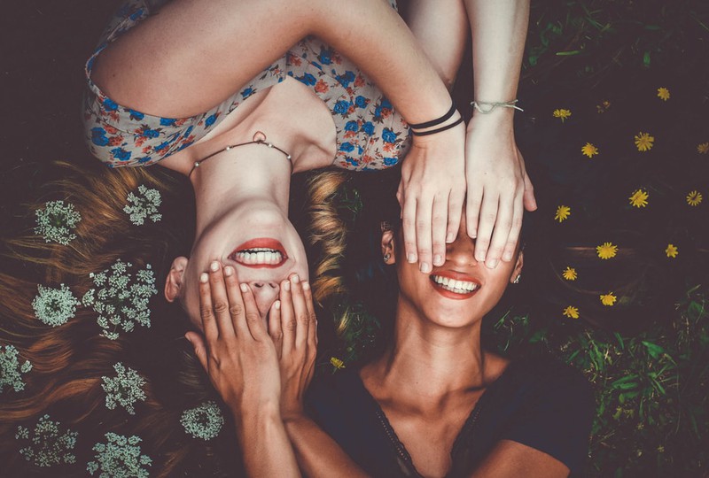 Frauen halten sich gegenseitig die Augen zu, um unbeobachtet zu sein