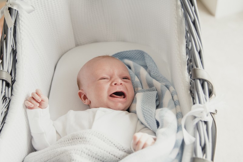 Baby liegt im Kinderwagen und heult