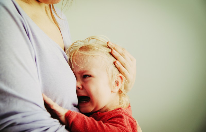 Baby weint an Mutters Brust