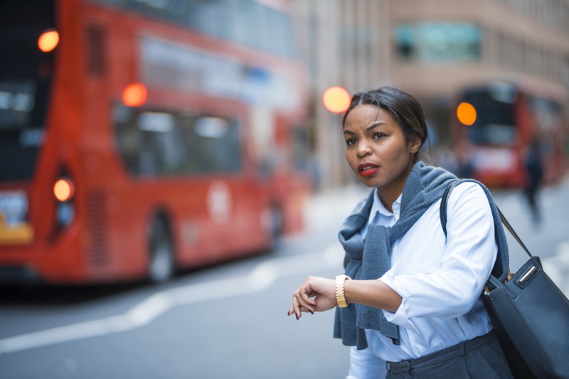 Frau wartet auf einen Bus