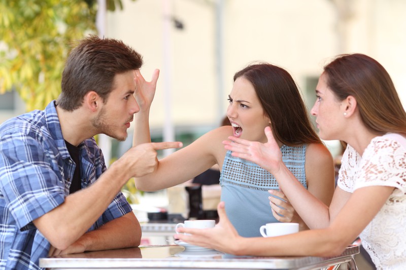 Zwei Frauen schreien einen Mann an