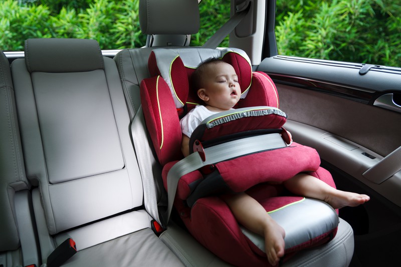 Kleiner Junge schläft im Auto