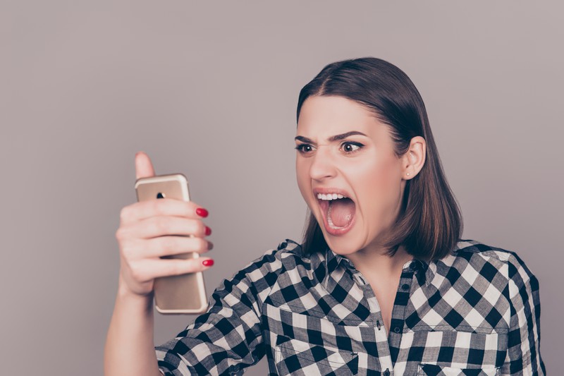 Frau schreit Telefon an