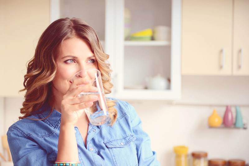 Eine Frau trinkt ein Glas Wasser