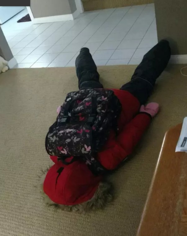 Kleines Kind liegt auf dem Teppich, weil es wieder zur Schule muss.