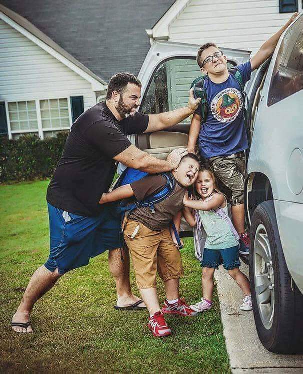 Vater schubst Kinder in den Wagen