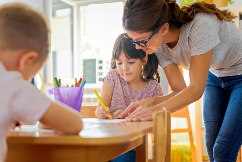 Kinder zeichnen mit Vorschullehrerin