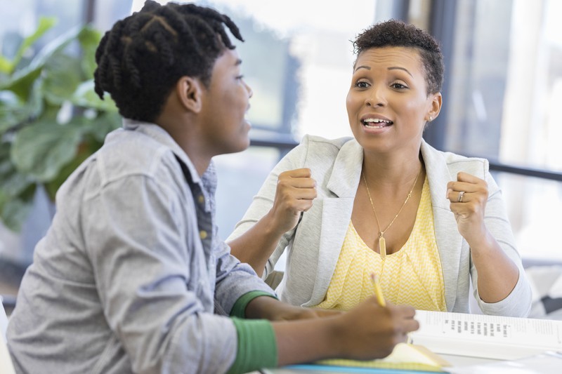 Lehrerin diskutiert mit Schüler