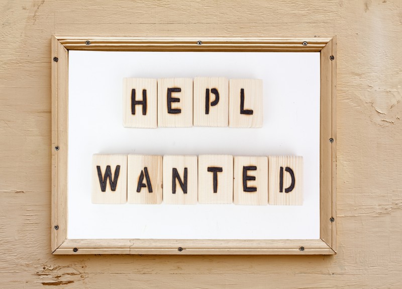 Schild, auf dem "Hepl Wanted" steht