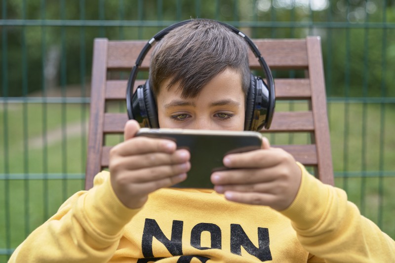 Ein Kind spielt mit seinem Smartphone und schaut ein Video