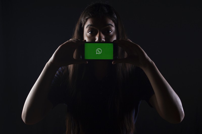 Frau mit einem Handy, das WhatsApp hat und die 6 Regeln