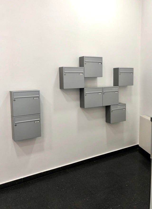 Die Briefkästen auf diesem Foto scheinen einfach in völlig willkürlicher Reihenfolge angebracht zu sein.