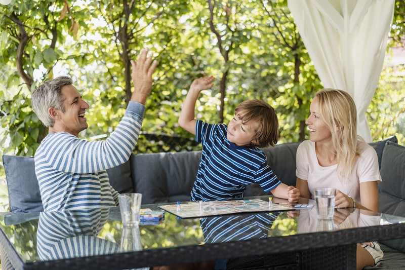 Man erkennt einen Vater, der sein Kind unterstützt und ein High Five gibt