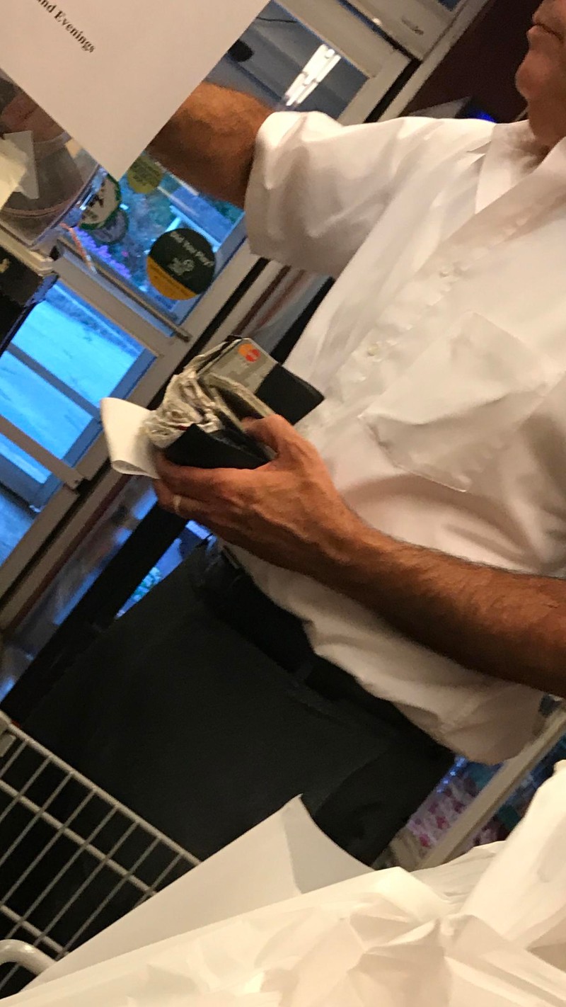 Ein Vater mit einem großen Portmornee mit ganz vielen Quittungen