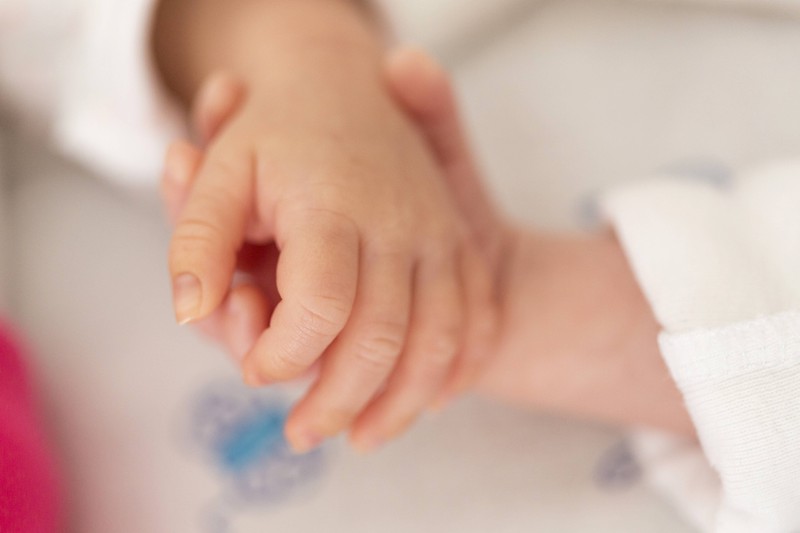 Neugeborene Zwillinge spenden sich Wärme, indem sie sich an der Hand halten