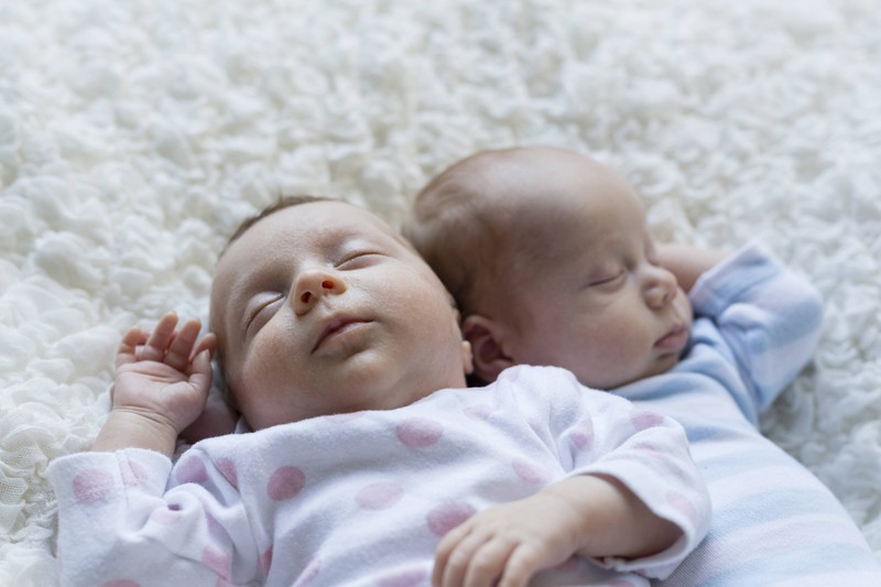 Zwillingsbabies, die nebeneinander liegen und friedlich schlummern