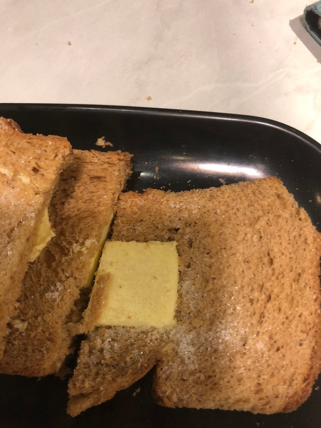 Das Foto zeigt ein Toastbrot mit Butter und Zucker.