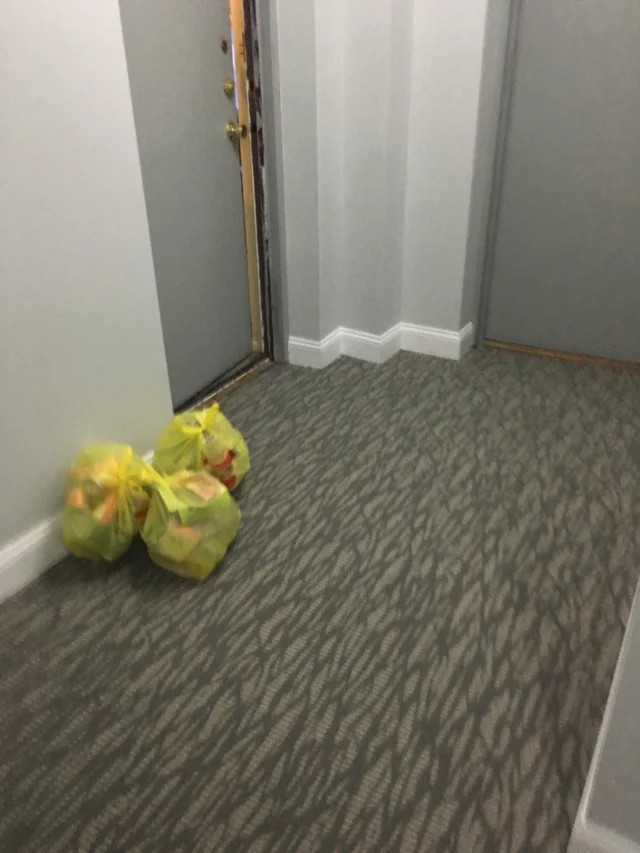 Man sieht einen Hausflur, in dem Müllsäcke liegen