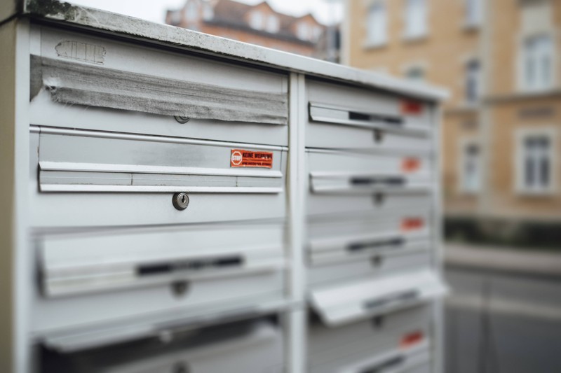 Man sieht einen Briefkasten mit mehreren Fächern, also mehrere Nachbarn