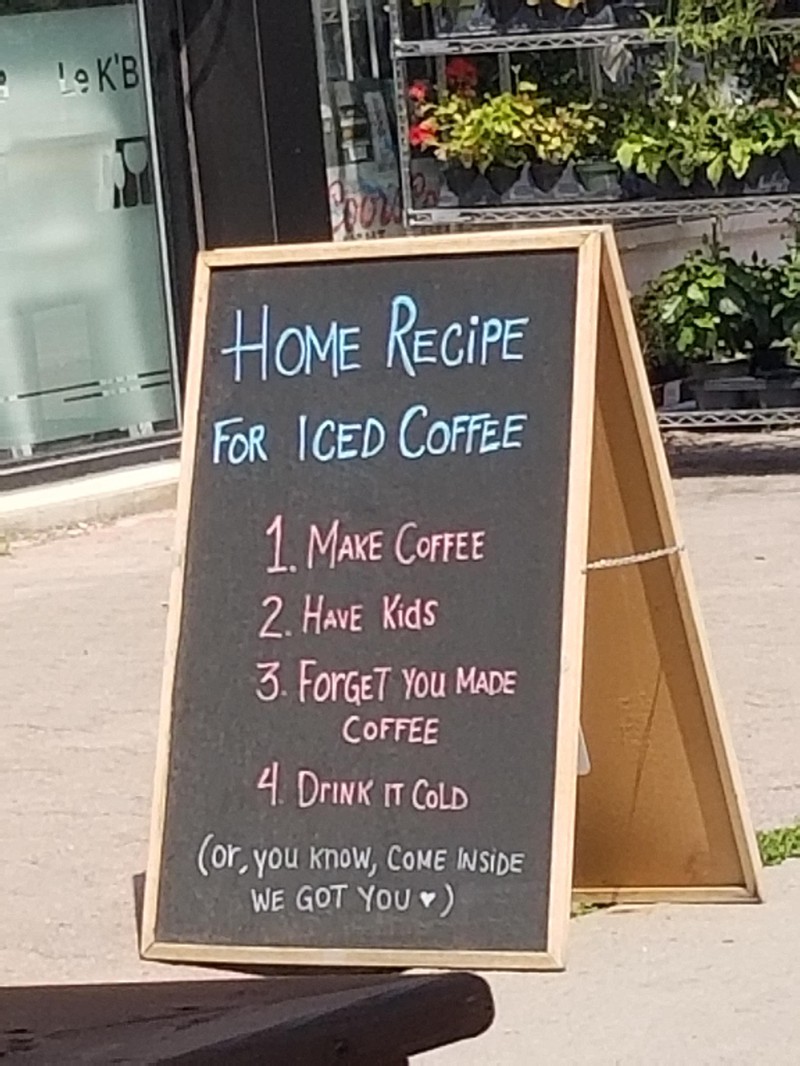 Lustige Werbetafel für Kaffee vor einem Restaurant
