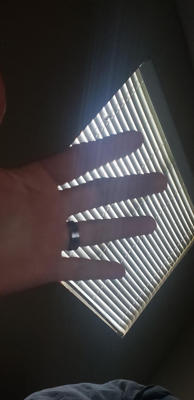 Finger, die gezackt aussehen, wenn man sie vor die Jalousie hält