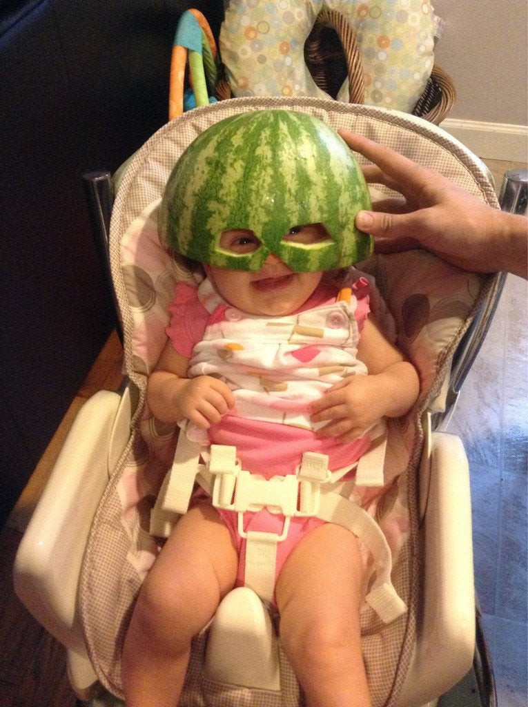 Ein Baby mit einer Maske aus einer Melonenschale