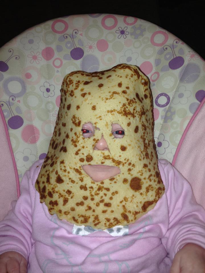 Ein Kind hat einen Pfannkuchen im Gesicht