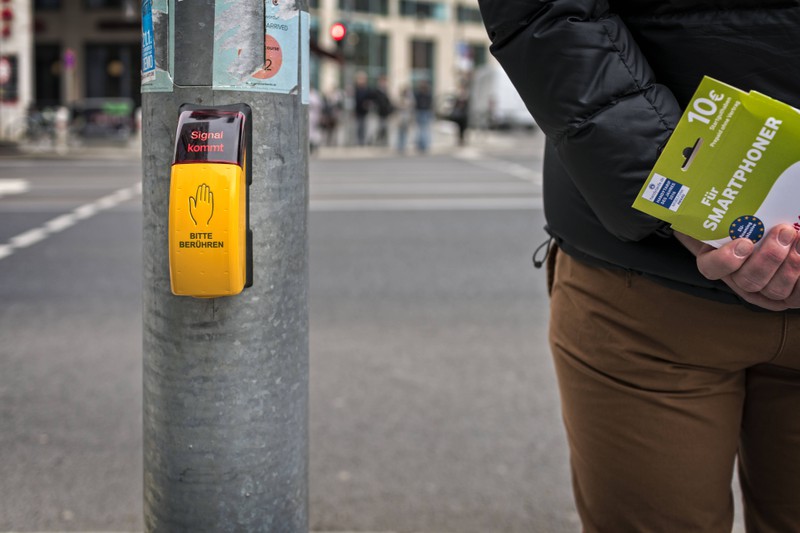 Fußgänger-Ampel mit einem Knopf, wo das Signal kommt