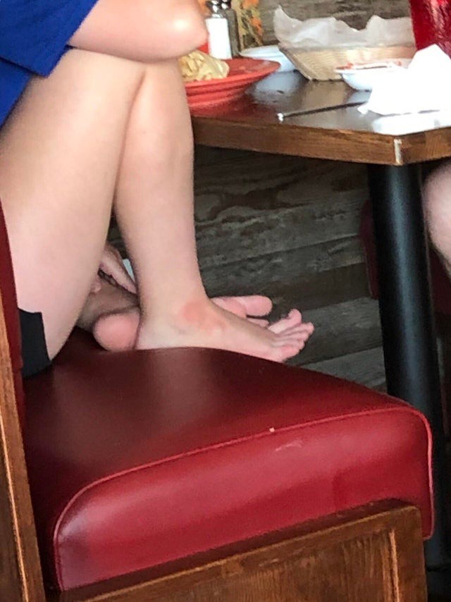 Eklige Restaurant-Besucherin: Sie hat ihre nackten Füße auf der Bank im Restaurant