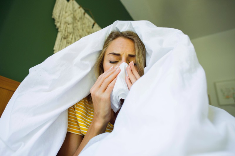Eine Frau ist erkältet im Bett