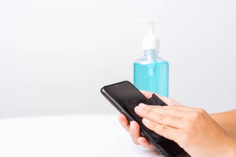 Ein Smartphone, das man desinfizieren sollte, weil sich sonst die Bakterien auf der Toilette verbreiten