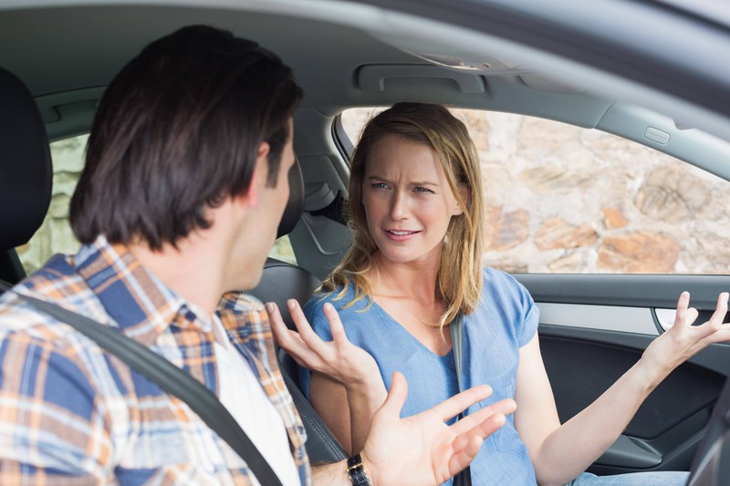 Junges Paar führt eine hitzige Diskussion, während sie im Auto sitzen.