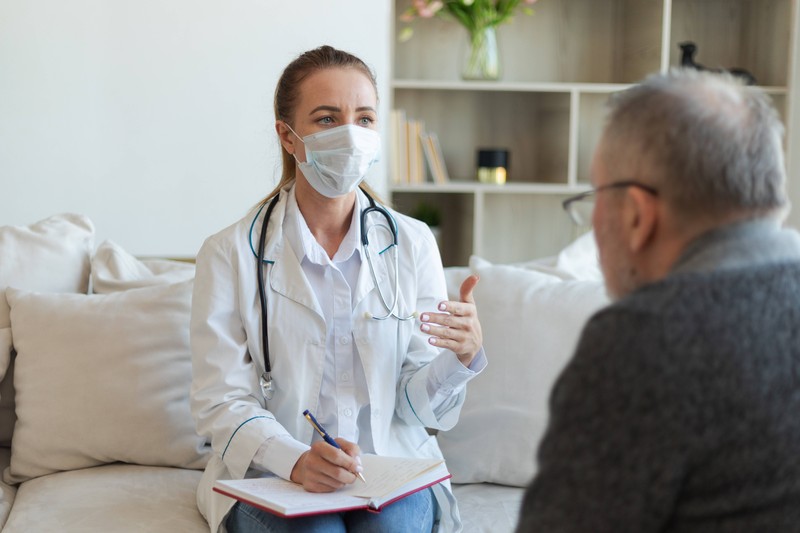 Eine Ärztin untersucht einen Mann auf eine Sepsis.